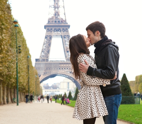 Young romantic couple kissing near the Eiffel Tower in Paris